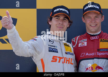 Pilote de course DTM canadien Robert Wickens (L'équipe HWA), et le Suédois Mattias Ekström (ABT Sportsline) position sur le poduim après la course sur le Norisring à Nuremberg, Allemagne, 14 juillet 2013.Wickens fut déclaré vainqueur par la suite après le pilote Audi Ekstroem a été disqualifié en raison d'une infraction du parc fermé. Photo : DAVID EBENER Banque D'Images