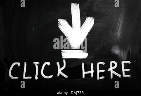 Cliquez ici à la main avec craie blanche sur un tableau noir Banque D'Images