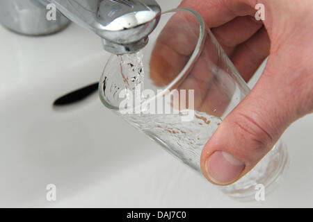 (Afp) un fichier photo datée du 24 février 2010 de l'eau et verser dans un verre à Munich, Allemagne. Photo : Lukas Barth Banque D'Images