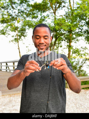 Merrick sud 14 juillet 2013 aux États-Unis. LUIS HERRERA, du Bronx, est en lui tendant le leurres de pêche qu'il a utilisé sur le quai de pêche à Levy Park & Preserve. Lui et ses amis n'ont pas attraper tous les poissons, mais la rive sud a aidé les vents les garder à l'aise, en tant que service météorologique national étendu son comité consultatif de chaleur à Long Island jusqu'au jour suivant. Une canicule dangereux se répand dans tout le nord-est, 92 degrés Celsius, 33 degrés Celsius. Credit : Ann E Parry/Alamy Live News Banque D'Images