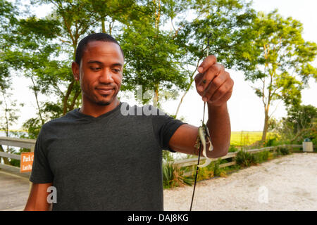 Merrick sud 14 juillet 2013 aux États-Unis. LUIS HERRERA, du Bronx, est en lui tendant le leurres de pêche qu'il a utilisé sur le quai de pêche à Levy Park & Preserve. Lui et ses amis n'ont pas attraper tous les poissons, mais la rive sud a aidé les vents les garder à l'aise, en tant que service météorologique national étendu son comité consultatif de chaleur à Long Island jusqu'au jour suivant. Une canicule dangereux se répand dans tout le nord-est, 92 degrés Celsius, 33 degrés Celsius. Credit : Ann E Parry/Alamy Live News Banque D'Images