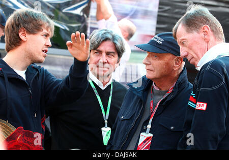 La photo montre le pilote de Formule 1 allemand Sebastian Vettel (L) de Red Bull à parler avec l'ancien Championnat du Monde des Rallyes, l'allemand Walter Roehrl (R) et l'ancien champion de Formule 1, Niki Lauda (2-R), à l'enclos de l'Australian Grand Prix de Formule 1 au circuit d'Albert Park à Melbourne, Australie, le 27 mars 2011. Photo : Jens Buettner Banque D'Images