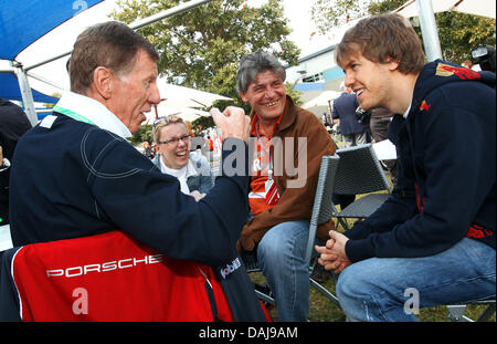 La photo montre l'allemand Sebastian Vettel, pilote de Formule 1 (R) de Red Bull à parler avec l'ancien champion du monde de rallye, l'allemand Walter Roehrl (L), dans le paddock du Grand Prix de Formule 1 d'Australie au circuit d'Albert Park à Melbourne, Australie, le 27 mars 2011. Photo : Jens Buettner Banque D'Images