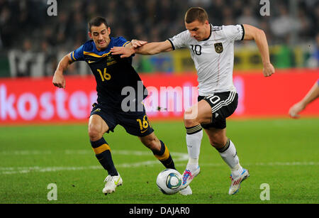 L'Allemagne Lukas Podolski (R) convoite la la balle avec l'Australie de Carl Valeri match amical international au cours de l'Allemagne contre l'Australie au Borussia-Park-Stadium de Moenchengladbach, Allemagne, 29 mars 2011. Photo : Thomas Eisenhuth Banque D'Images