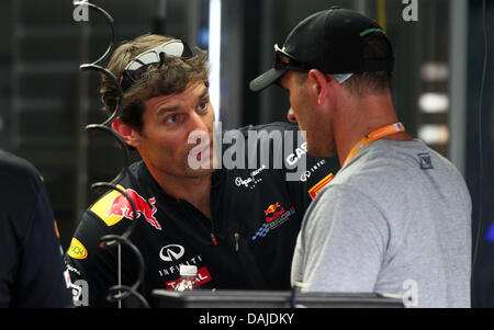 Australian pilote de Formule 1 Mark Webber (L) de Red Bull vérifie sa voiture dans le garage à l'extérieur du circuit de Sepang, Kuala Lumpur, Malaisie, 07 avril 2011. Le Grand Prix de Formule 1 de Malaisie aura lieu le 10 avril 2011. Photo : Jens Buettner dpa Banque D'Images