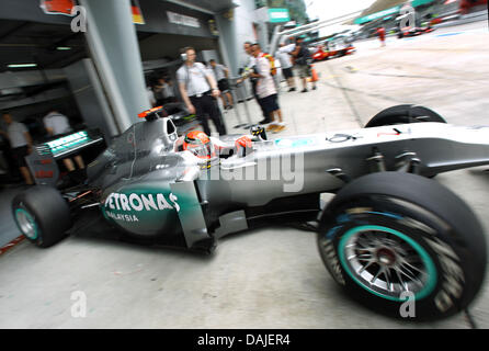 Pilote de Formule 1 allemand Michael Schumacher de Mercedes GP conduit sa voiture de course dans l'aire des puits au cours de la troisième session d'essais au circuit de Sepang, à l'extérieur de Kuala Lumpur, Malaisie, 09 avril 2011. Le Grand Prix de Formule 1 de Malaisie aura lieu le 10 avril 2011. Photo : Jens Buettner dpa Banque D'Images