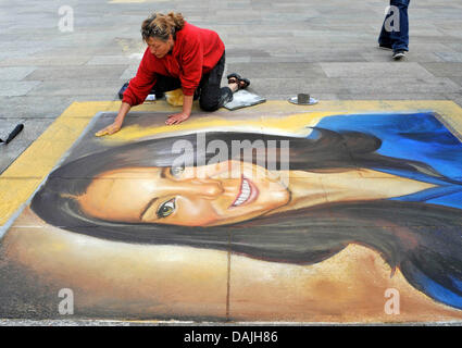 Artiste de rue Marion Ruthhardt travaille sur son portrait à la craie de Kate Middleton, la future épouse du Prince William, sur le terrain en face de la cathédrale au cours de la production d'une vidéo à Cologne, Allemagne, 11 avril 2011. Varell est en train de produire une vidéo pour sa chanson "Es ist nicht leicht Prinzessin zu sein" ("Ce n'est pas facile d'être une princesse'). Photo : HENNING KAISER Banque D'Images