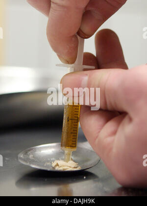 (Afp) - Une archive photo datée du 25 janvier 2007, indique la part d'un utilisateur de drogue qui remplit sa seringue d'héroïne à Francfort, Allemagne. Malgré la diminution des décès liés à la drogue, la police a déclaré toutefois que le montant de l'aide aux consommateurs de drogues dures n'a cessé d'augmenter au total. Photo : Boris Roessler Banque D'Images