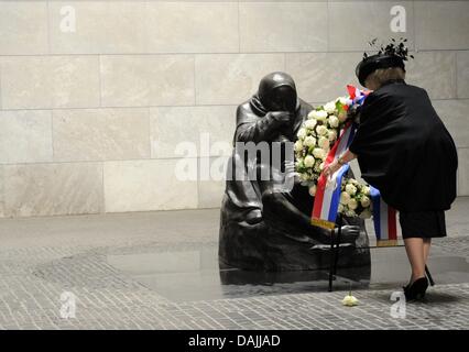 La Reine Beatrix des Pays-Bas établit une couronne en face de la sculpture Kaethe Kollwitz "mère avec son fils mort' à Neue Wache (nouveau poste de garde) à Berlin, Allemagne, 12 avril 2011. Neue Wache est le mémorial central de la République fédérale d'Allemagne pour les victimes de la guerre et de la tyrannie. La famille royale est sur une quatre jours, visite en Allemagne. Photo : Maurizio Gambarini Banque D'Images