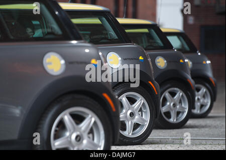 Une rangée de 'Mini' e modèles de voiture par un bouchon de carburant doté d''une fiche d'alimentation et le logo de l'entreprise de fournisseur d'énergie Vattenfall sont affichés lors d'une conférence de presse à Berlin, Allemagne, 31 mars 2011. Le constructeur automobile allemand BMW et Vattenfall continueront leur projet pilote concernant l'utilisation de ces modèles de voitures électriques dans les centres urbains. Photo : Tobias Kleinschmidt Banque D'Images