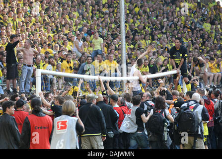 Sur le palonnier Siiting Dortmund's player Lucas Barrios (R) (Argentine) célèbre le triomphe et l'équipe de championnat du titre avec les fans après Bundesliga match Borussia Dortmund vs 1. FC Nuremberg au Signal Iduna Park de Dortmund, Allemagne, 30 avril 2011. Le Borussia Dortmund est champion de football allemand pour la septième fois. Dortmund a gagné par 2-0. Photo : Friso Gentsch Banque D'Images