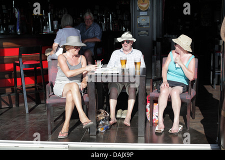 Les touristes au soleil dans un bar, le port de plaisance, l'Vilamora, Algarve, Portugal. Banque D'Images