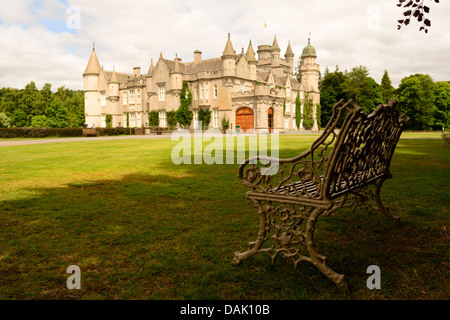 Vue horizontale de Le Château de Balmoral, la résidence d'été de la famille, du jardin sur une journée ensoleillée avec banc en premier plan Banque D'Images