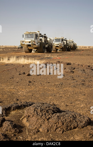 L'exploration du pétrole au Mali. Vibrateur sismique des véhicules se déplaçant à travers désert et frottez le relief levé géophysique de concession. Banque D'Images