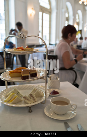 dh Hotels Tiffin Room table RAFFLES HOTEL SINGAPORE High Tea présentoir à gâteaux sandwiches gâteaux thé soucoupe personnes intérieur de l'après-midi Banque D'Images