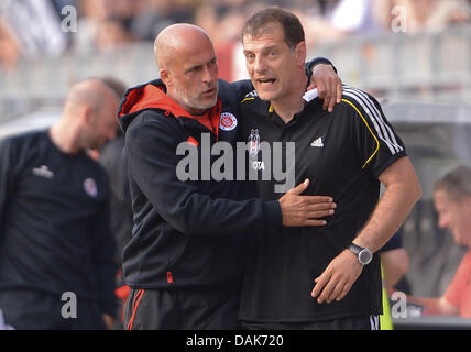 St Pauli entraîneur en chef Michael Frontzeck (L) et l'entraîneur-chef' Besiktas Slaven Bilic hug après le test-match de foot entre FC St Pauli et Besiktas Jimnastik Kuluebue au stade Millerntor à Hambourg, Allemagne, 12 juillet 2013. St Pauli a gagné 1-0. Photo : Axel Heimken Banque D'Images