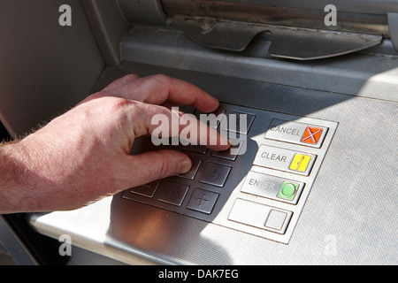 Atm cash machine d'exploitation de l'homme saisie du NIP London, England uk Banque D'Images