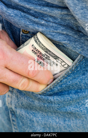Mans part mettre des dollars dans sa poche de jean Banque D'Images