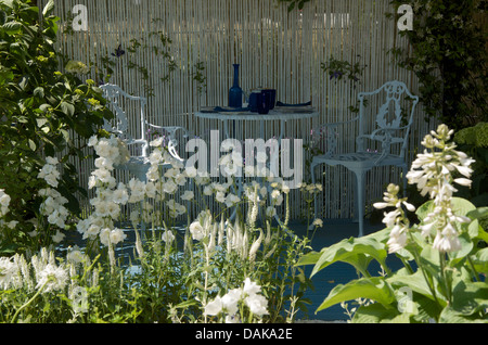 Une table et deux chaises dans le jardin d'été à motif saule RHS Hampton Court Palace Flower Show 2013. Banque D'Images