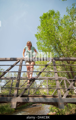 Femme sur le pont rambarde regardant par-dessus. Banque D'Images