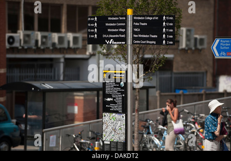 Scène de rue dans le centre-ville de Wimbledon avec panneau d'information pour piétons Banque D'Images