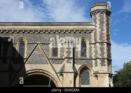 Une ancienne porterie bâtiment construit de silex et de ciment avec des fenêtres en verre au plomb, des gargouilles et une tour. Banque D'Images