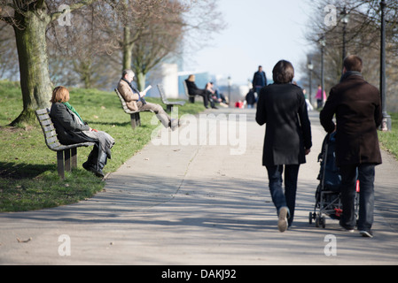 Les gens se détendre sur des bancs de parc sur Primrose Hill, Londres Banque D'Images