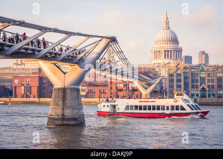 Un touriste bateau de vitesse passe sous le Millennium Bridge, Londres avec la cathédrale St Paul à l'arrière-plan Banque D'Images