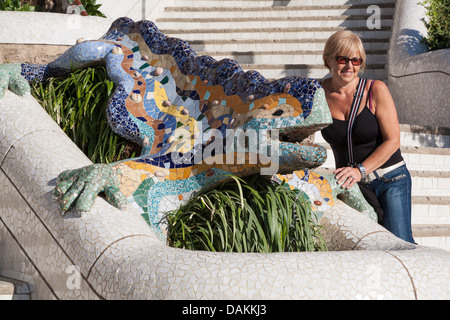 Woman posing with El Drac à l'entrée principale du Parc Güell - Gràcia, Barcelone, Catalogne, Espagne Banque D'Images