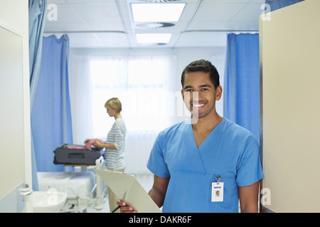 Nurse holding clipboard in hospital room Banque D'Images