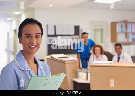 Nurse smiling in hospital hallway Banque D'Images