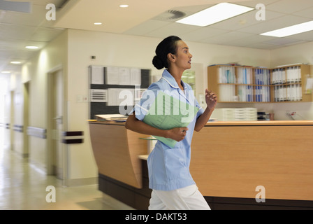 Nurse rushing in hospital hallway Banque D'Images