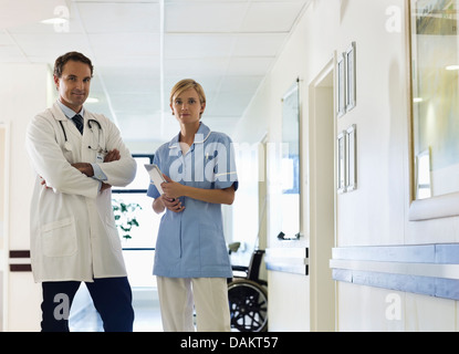 Doctor and nurse standing in hospital hallway Banque D'Images