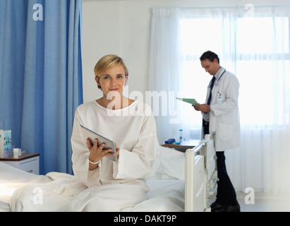 Patient using tablet computer in hospital room Banque D'Images