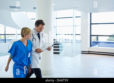 Doctor and nurse talking in hospital hallway Banque D'Images