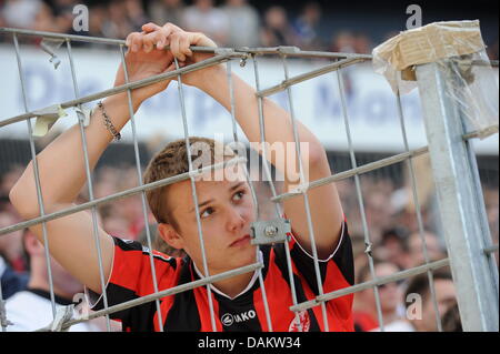 Un jeune fan de Francfort se penche déçus contre une clôture après le match de football de la Bundesliga entre 1er FC Cologne et de l'Eintracht Francfort à la Commerzbank Arena de Francfort, Allemagne, le 7 mai 2011. Cologne a remporté le match 2-0. Photo : Arne Dedert Banque D'Images