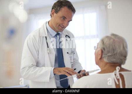 Doctor talking to older patient in hospital Banque D'Images
