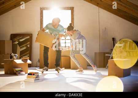 Couple unpacking boxes in attic Banque D'Images