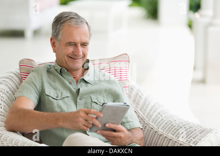 Older Man using tablet computer on porch Banque D'Images