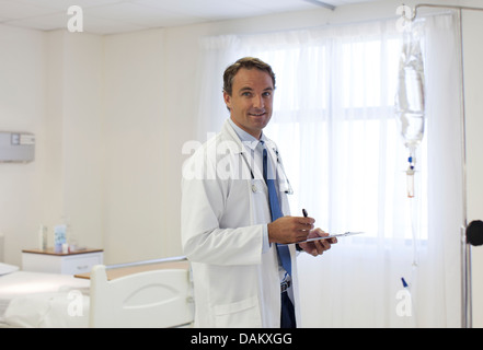 Doctor writing on clipboard in hospital Banque D'Images