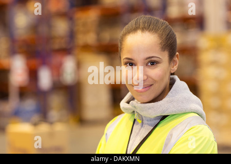 Worker smiling in warehouse Banque D'Images