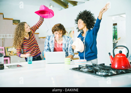 Amis jouant dans la cuisine Banque D'Images