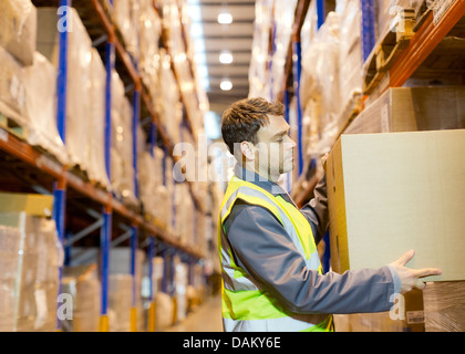 Empilage travailleur boxes in warehouse Banque D'Images