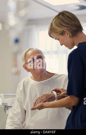 Infirmière lisant plus bracelet médical du patient à l'hôpital Banque D'Images