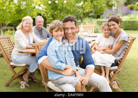 Family smiling at table outdoors Banque D'Images