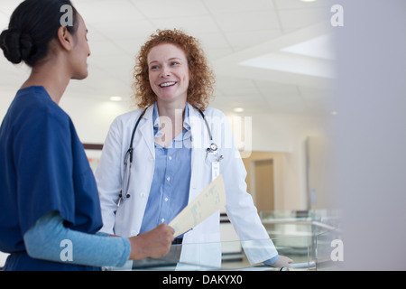 Doctor and nurse talking in hospital hallway Banque D'Images