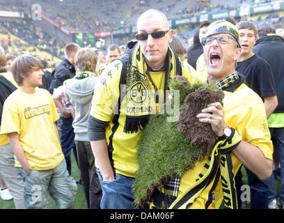 Les fans de Dortmund pièces d'attente à partir de la hauteur du gazon après la Bundesliga match Borussia Dortmund vs Eintracht Frankfurt au Signal-Iduna-Park à Dortmund, en Allemagne, le 14 mai 2011. Dortmund est Champion de Bundesliga de la saison 2010-2011. Photo : Federico Gambarini (ATTENTION : EMBARGO SUR LES CONDITIONS ! Le LDF permet la poursuite de l'utilisation des images dans l'IPTV, les services mobiles et d'autres se Banque D'Images