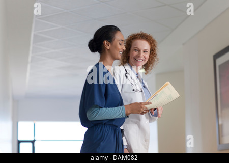 Doctor and nurse talking in hospital hallway Banque D'Images