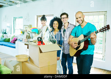 Friends smiling in new home Banque D'Images