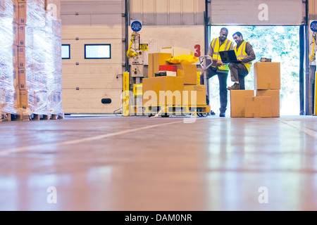 Workers checking boxes in warehouse Banque D'Images